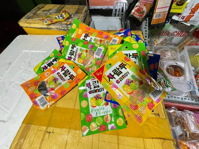 Bánh kẹo từ hương liệu không rõ nguồn gốc xuất xứ bày bán tràn lan ngoài cổng trường. Nguồn: Internet