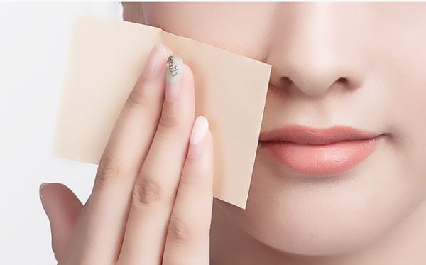 Sử dụng giấy thấm dầu trước khi dặm lại lớp trang điểm.